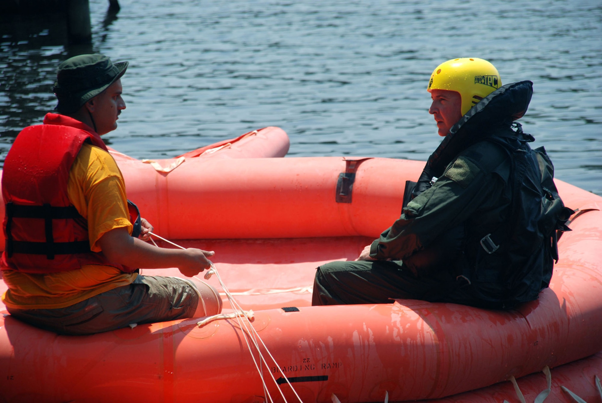 Aircrew Flight Equipment technician, Tech. Sgt. Brad Schoth, provides 917th Operations Group Commander, Col. Robert Nordberg, with general information about the 20-man life raft during water survival training at Black Bayou Reservoir on August 2. (U.S. Air Force photo by Tech. Sgt. Andre Menard) (Released)  
