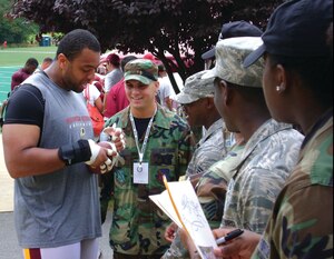 Demetric Evans, Washington Redskins defensive end, signs autographs for a group of Andrews Airmen who were invited to Redskins Park in Loudon County, Va., to watch the team practice for the 2008-2009 season. The Airmen were also given a tour of the Redskins training facility.