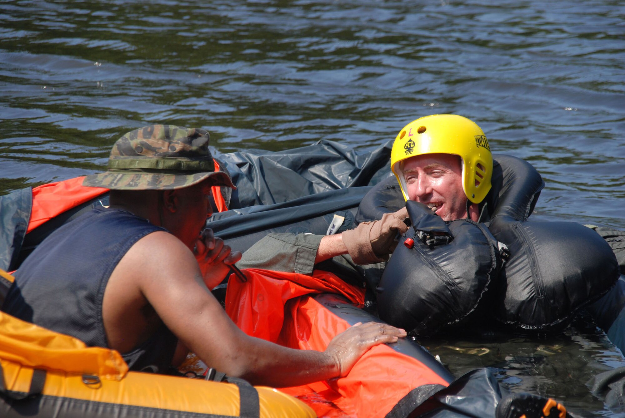 Aircrew Flight Equipment technician, Tech. Sgt. Albertus Alexander, gives 93rd Bomb Squadron aircrew member, Maj. Andrew Werner, general information about the LRU 16/P, one-man life raft.  during water survival training at Black Bayou Reservoir on August 2. (U.S. Air Force photo by Tech. Sgt. Andre Menard) (Released) 