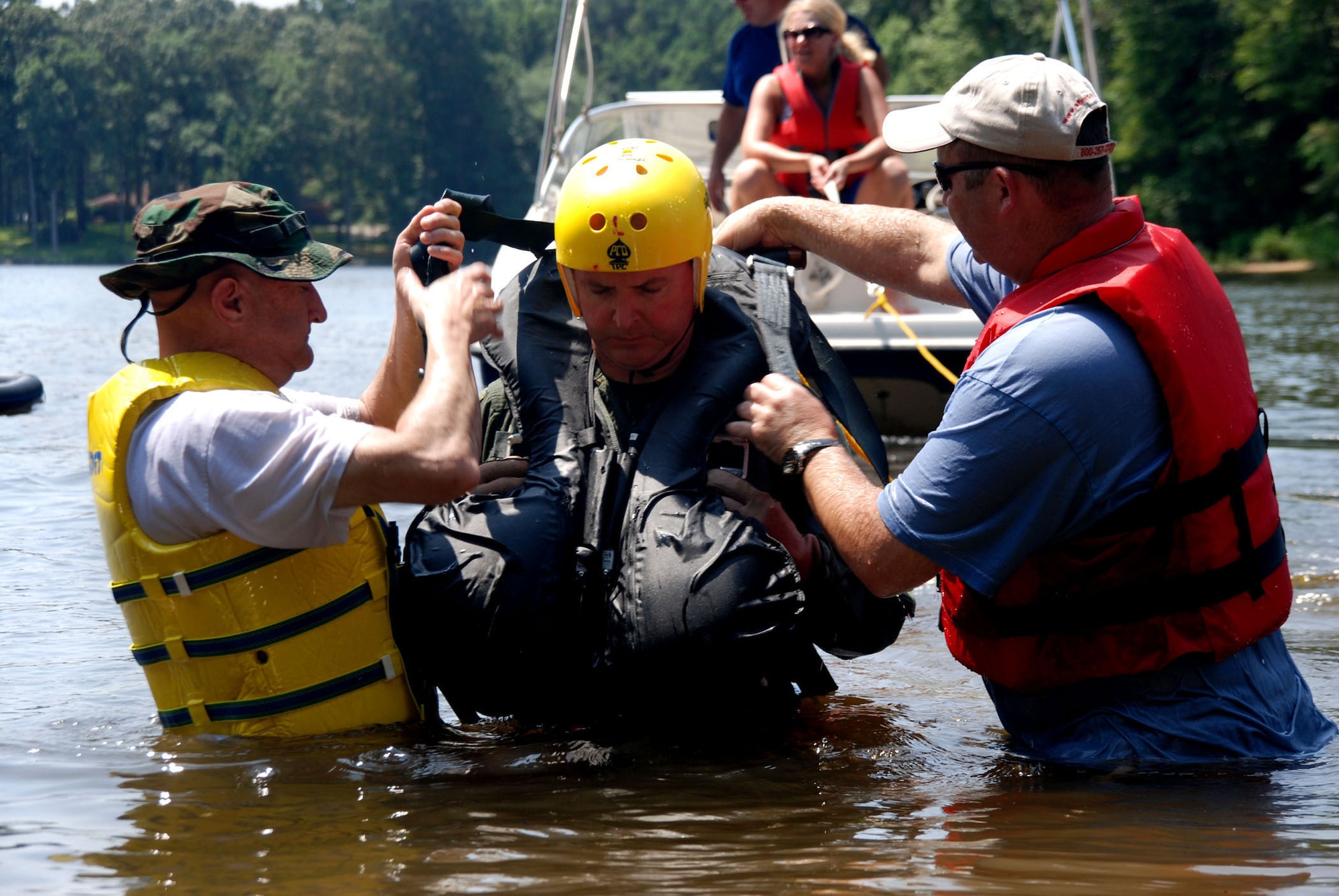 Col. Robert Nordberg, 917th Operations Group commander, is assisted with his harness by fellow 93rd Bomb Squadron aircrewmen, Lt. Col. Timothy Mers and Capt Ben Bowman during water survival training at Black Bayou Reservoir on August 2.   This station is used to instruct the aircrew on proper release techniques in the event of a canopy wind drag. (U.S. Air Force photo by Tech. Sgt. Andre Menard) (Released)