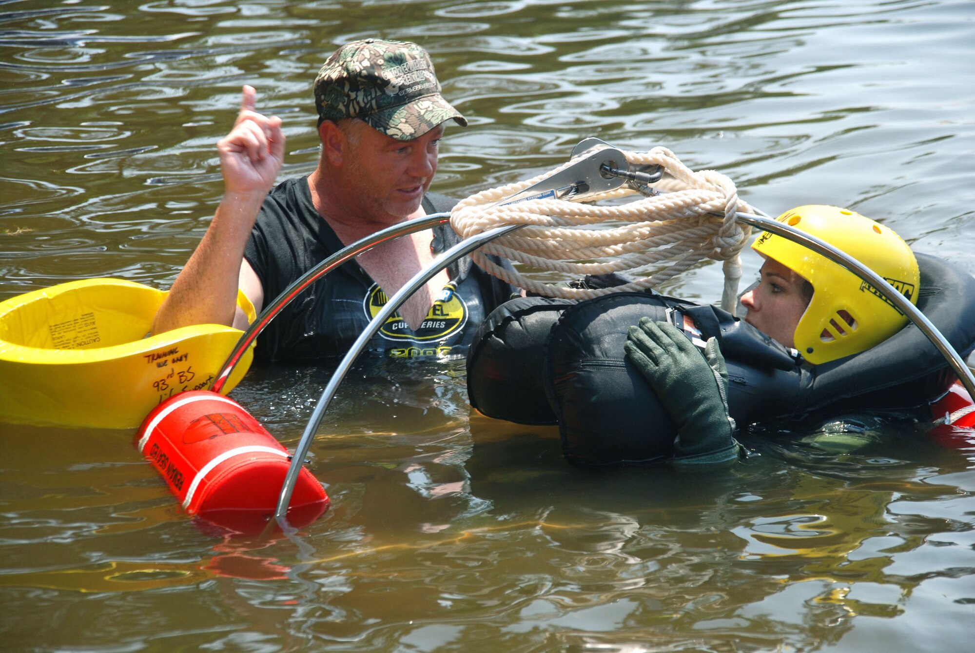 Capt. Heather Decker, a 93rd Bomb Squadron pilot listens as Aircrew Flight Equipment technician, Master Sgt. Joel Womach instructs her on proper rescue techniques of the Coast Guard rescue backet during water survival training at Black Bayou Reservoir on August 2.  (U.S. Air Force photo by Tech. Sgt. Andre Menard) (Released)