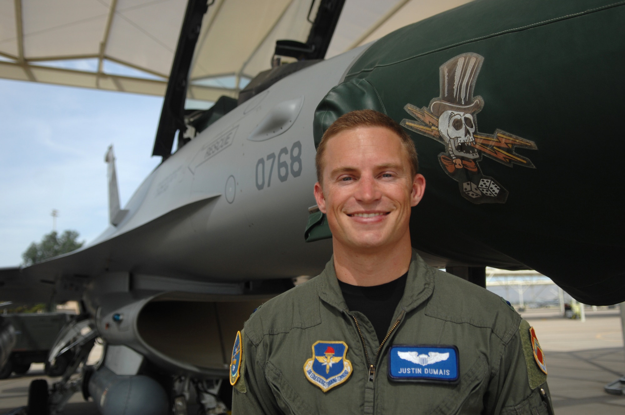 1st Lt. Justin Dumais, 310th FS student F-16 pilot, stands in front of an F-16 at Luke AFB. Lt. Dumais competed in the 2004 Olympics as a syncronized diver with his brother Troy in Athens, Greece. Lt. Dumais now serves in the U.S. Air Force while his brother Troy continued diving and competed in the 2008 Olympics in Beijing. (U.S. Air Force photo by TSgt. Jeffrey Wolfe) 