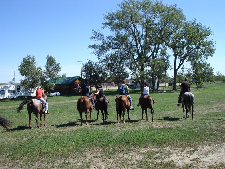 KILLDEER, N.D. -- A group from Minot Air Force Base sets off on horseback for a trail ride in the Badlands here Aug. 16 as part of a summer trip sponsored by 5th Force Support Squadron Outdoor Recreation. With the help of two guides, almost 20 men, women and children from Minot AFB participated in the scenic ride. The Outdoor Recreation trip included transportation to/from base, a three-hour horseback ride and lunch. For information on upcoming Outdoor Recreation trips and activities, contact 723-3648. (U.S. Air Force photo by Maj. Elizabeth Ortiz)