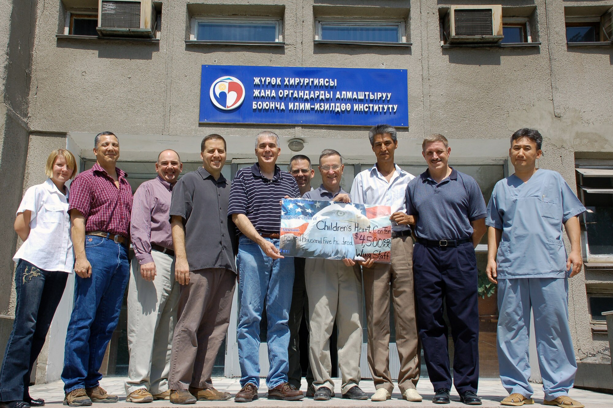 Airmen from several 376th Air Expeditionary Wing staff agencies at Manas Air Base, Kyrgyzstan, present a check for $4,500 Aug. 18 to Dr. Shabyraliev Esenbekovich (right), senior cardiac surgeon at the Institution of Cardiac Surgery and Organ Transplantation in Bishkek, Kyrgyzstan.  The donation was the largest single monetary contribution given by base Airmen to the institution, also known as the "Children's Heart Hospital." The donations cover expenses for life-saving surgeries on local children.  (U.S. Air Force photo/Maj. Damien Pickart)