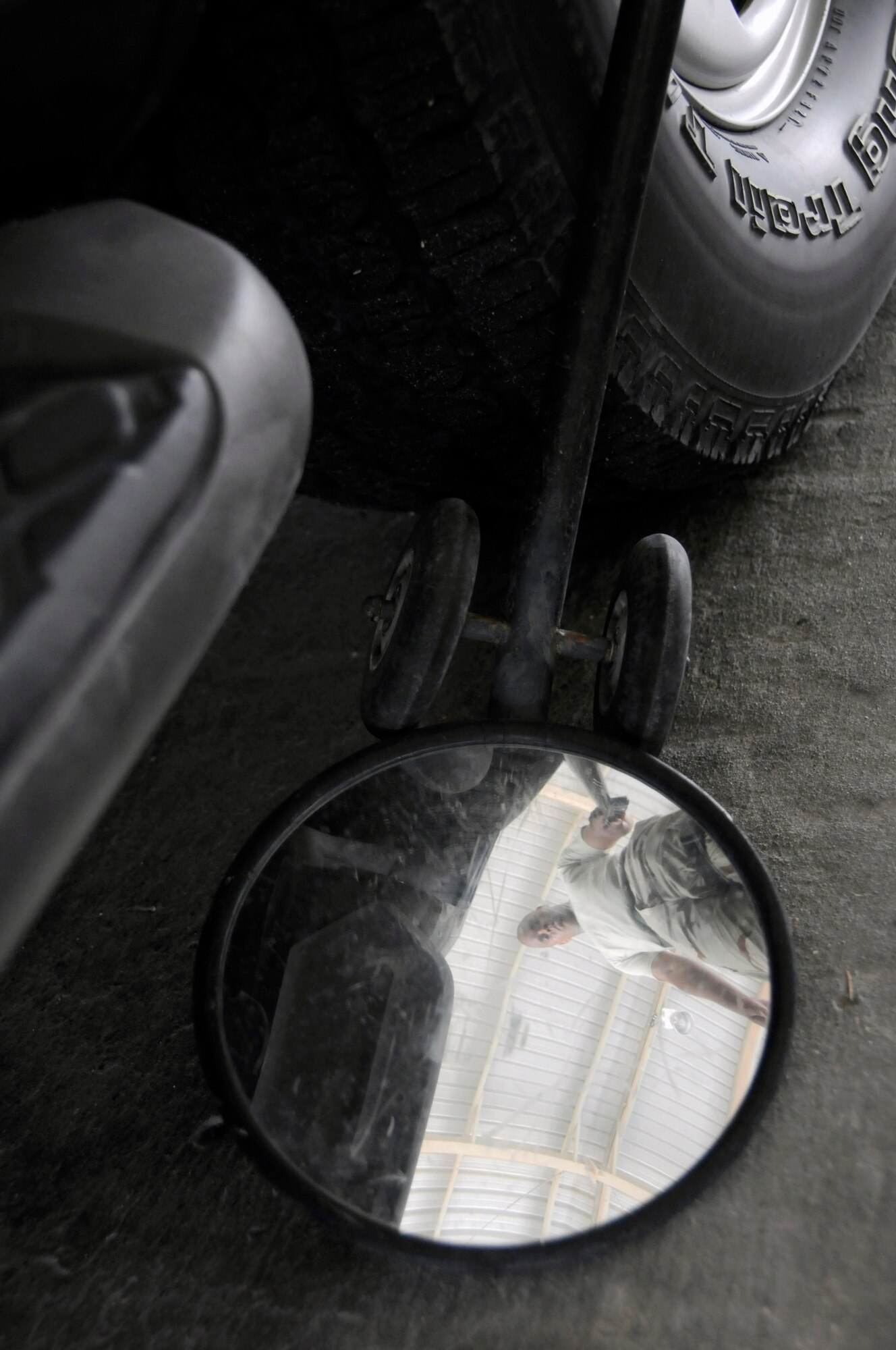 Senior Airman Ron Turner, a search member assigned to the 379th Expeditionary Security Forces Squadron, uses a search mirror to inspect the undercarriage of a vehicle Aug. 19 at an air base in Southwest Asia.  Airman Turner and the rest of his team ensure the safety and security of the air base by carefully inspecting all incoming vehicles for explosives and weapons. Airman Turner, a native of Jacksonville, Fla., is deployed from Randolph Air Force Base, Texas.  (U.S. Air Force photo/Staff Sgt. Darnell T. Cannady)
