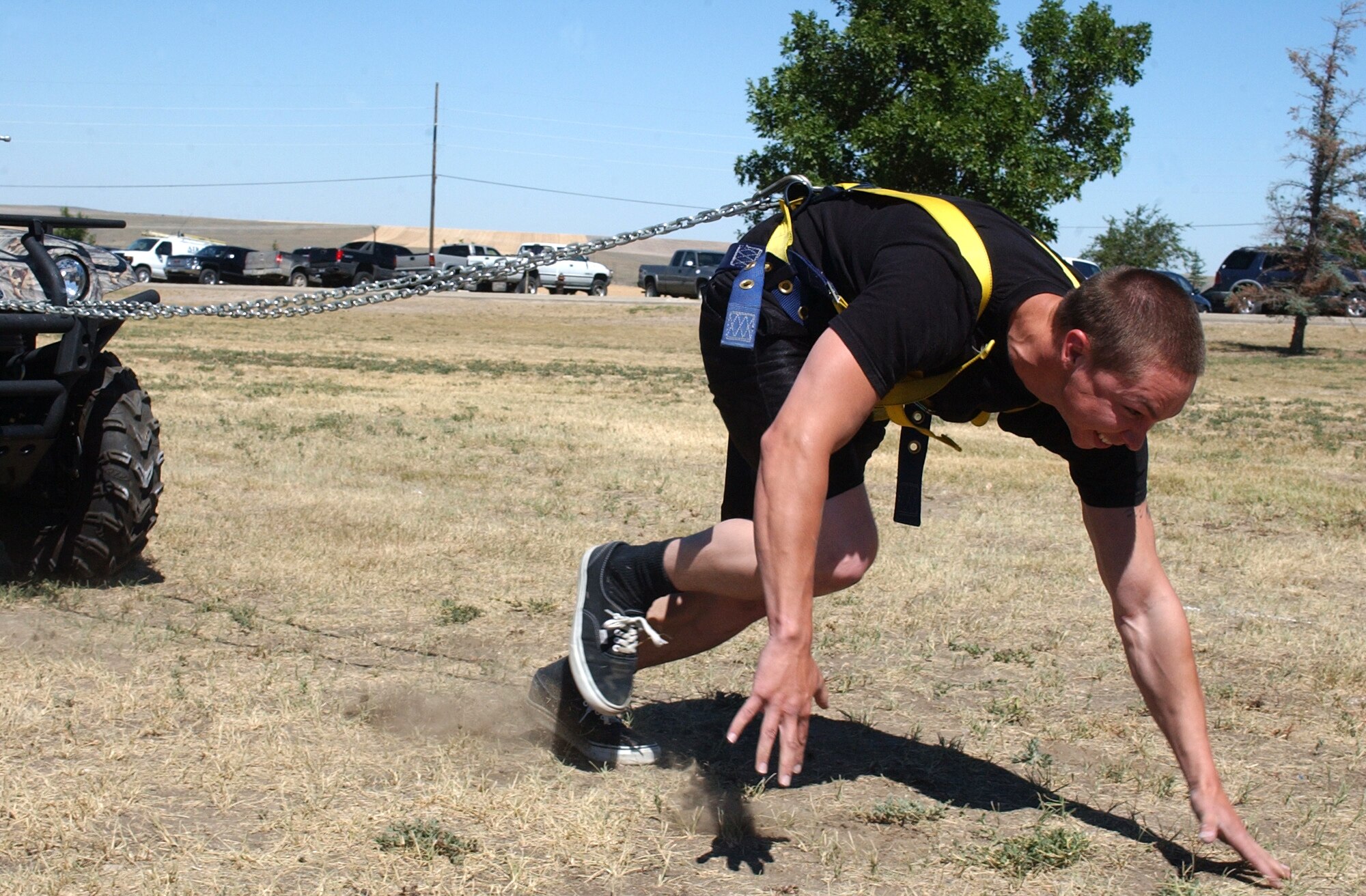 Airman Alex Mendoza strains to reach the finish line in the "ATV Pull" portion of the Grizzly Challenge strength competition at the Malmstrom Air Force Base Picnic Aug. 15.  Competitors pulled a full-size four-wheel all-terrain-vehicle 80 feet and were scored on how fast they covered the distance.  Airman Mendoza is a member of the 341st Security Forces Squadron.  His time in this event was 16.75 seconds and he won the overall competition in the Lightweight Division.  (U.S. Air Force photo/Maj. David Kurle)                               