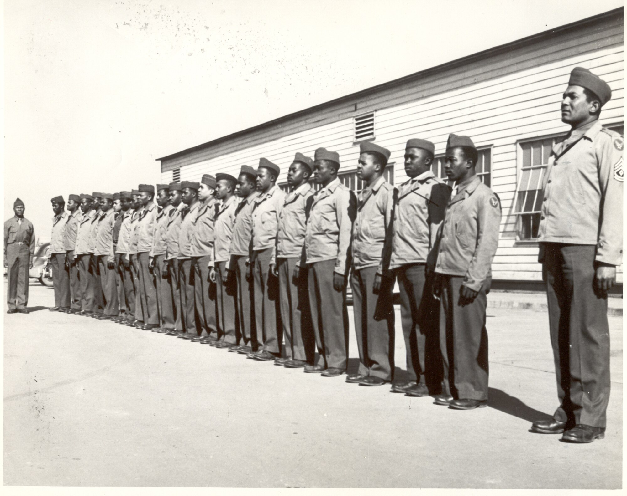 Members of the 46th Aviation Squadron stand at attention outside a barrack awaiting inspection. The 46th along with the 934th Quater Master Platoon were the first black units to arrive at Scott. 