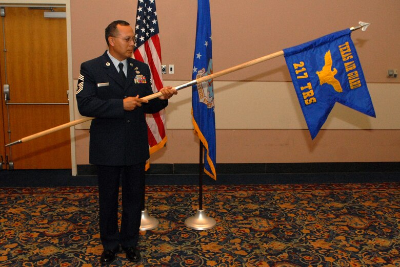 Chief Master Sgt.  Pedro Tambunga holds the guideon during an assumption of command ceremony for the Texas Air National Guard's 217th Intelligence Training Sqadron held Friday at Goodfellow AFB, Texas.  The formal ceremony marked the official inception of the squadron whose instructiors will integrate with Goodfellow's 17th Training Group to teach Air Force active duty, Guard and Reserve intellegence officers and enlisted technical school students. (Photo by Senior Airman Kasabyan Musal) 
