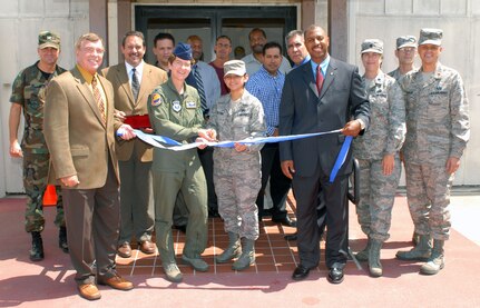 Col. Jacqueline Van Ovost, 12th Flying Training Wing commander, helps Senior Airman Vanessa Trevino (center), Jim Grobe (left, holding ribbon) and James Williams, all 12th Mission Support Group Logistics Readiness Division, dedicate the new Deployment Processing Center on Randolph Air Force Base, Texas, Aug. 14. (U.S. Air Force photo by Steve White)
