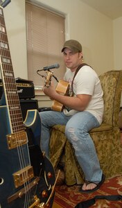 Capt. Steve Wilson, 563rd Flying Training Squadron, takes time to work on his songwriting at his home on Randolph Air Force Base, Texas, Aug. 19. His song, "Ask Me To," won top honors in the "Songs From the Soul of Service" Department of Defense songwriting contest recently. (U.S. Air Force photo by Rich McFadden)