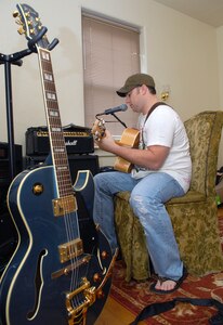 Capt. Steve Wilson, 563rd Flying Training Squadron, takes time to work on his songwriting at his home on Randolph Air Force Base, Texas, Aug. 19. His song, "Ask Me To," won top honors in the "Songs From the Soul of Service" Department of Defense songwriting contest recently. (U.S. Air Force photo by Rich McFadden)