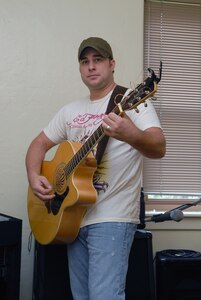 Capt. Steve Wilson, 563rd Flying Training Squadron, takes time to work on his songwriting at his home on Randolph Air Force Base, Texas, Aug. 19. His song, "Ask Me To," won top honors in the "Songs From the Soul of Service" Department of Defense songwriting contest recently. (U.S. Air Force photo by Rich McFadden)