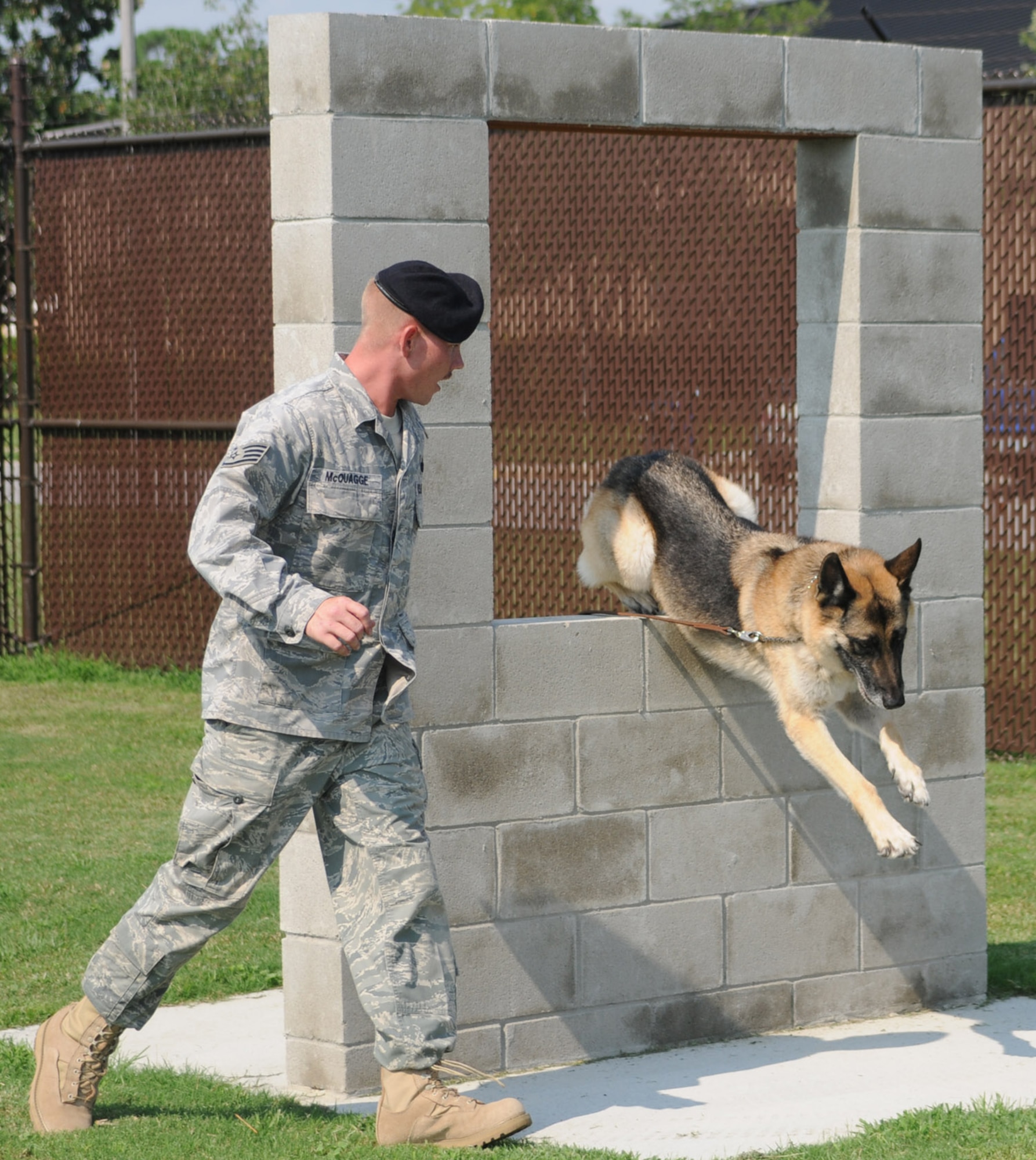 Sergeant McQuagge runs Bobby through an obstacle course to prepare for various situations they may encounter while deployed or on patrol.  (U.S. Air Force photo by Kemberly Groue)