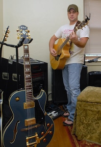 Capt. Steve Wilson, 563rd Flying Training Squadron, takes time to work on his songwriting at his home on Randolph Air Force Base, Texas, Aug. 19. His song, "Ask Me To," won top honors in the "Songs From the Soul of Service" Department of Defense songwriting contest recently. (U.S. Air Force photo by Rich McFadden)