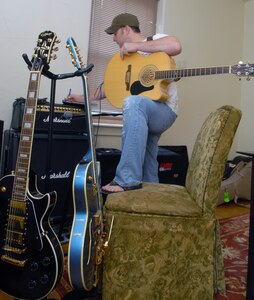 Capt. Steve Wilson, 563rd Flying Training Squadron, takes time to work on his songwriting at his home on Randolph Air Force Base, Texas, Aug. 19. His song, "Ask Me To," won top honors in the "Songs From the Soul of Service" Department of Defense songwriting contest recently. (U.S. Air Force photo by Rich McFadden)