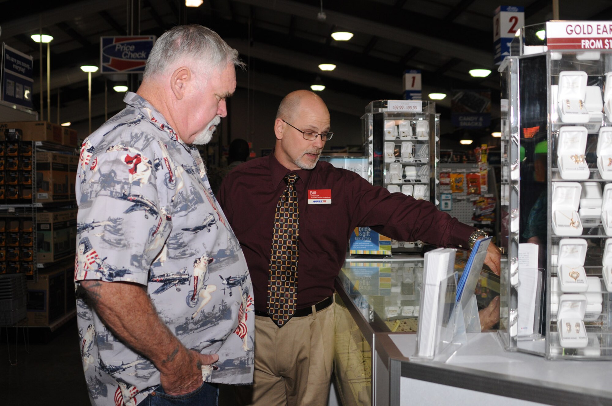 Navy retiree William Rhodes Jr. of D’Iberville, left, and base exchange store manager Bill Buell look at a jewelry display case.   Mr. Rhodes was one of three regional first place winners in an Army and Air Force Exchange Service sweepstakes kicking off the new Military Star Rewards Master Card program.   Mr. Rhodes purchased a television and other merchandise with his five $1,000 AAFES gift cards.  (U.S. Air Force photo by Kemberly Groue)
