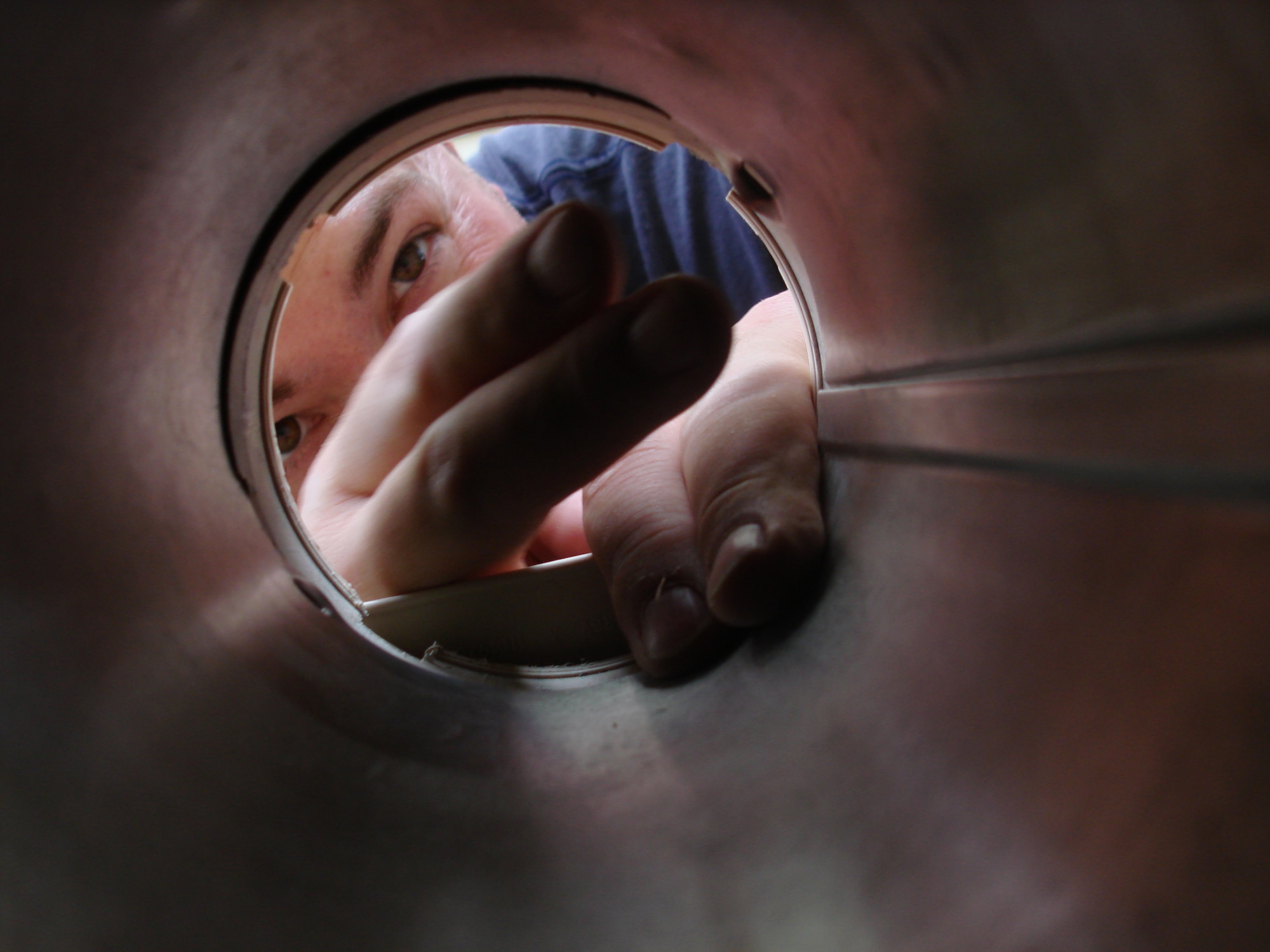 Tech. Sgt. Craig Bittinger, 21st Air Mobility Operations Squadron, installs a vent duct for the washer and dryer connections Aug. 16 at Habitat for Humanity site in Beverly, N.J. Airmen from 21st AMOS helped build houses for the Habitat organization in Burlington County. (U.S. Air Force photo/Staff Sgt. Francis Lalic)