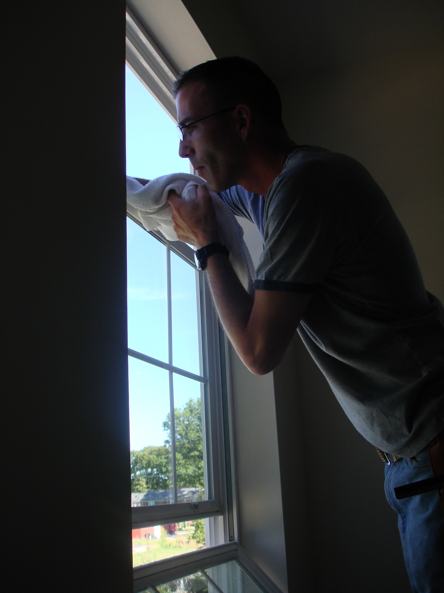 Master Sgt. Greg Patterson, 21st Air Mobility Operations Squadron, washes the windows prior to the house inauguration at Habitat for Humanity house in Beverly, N.J., Aug. 16. Habitat for Humanity is a nonprofit organization that builds affordable houses for low income families. (U.S. Air Force photo/Staff Sgt. Francis Lalic)