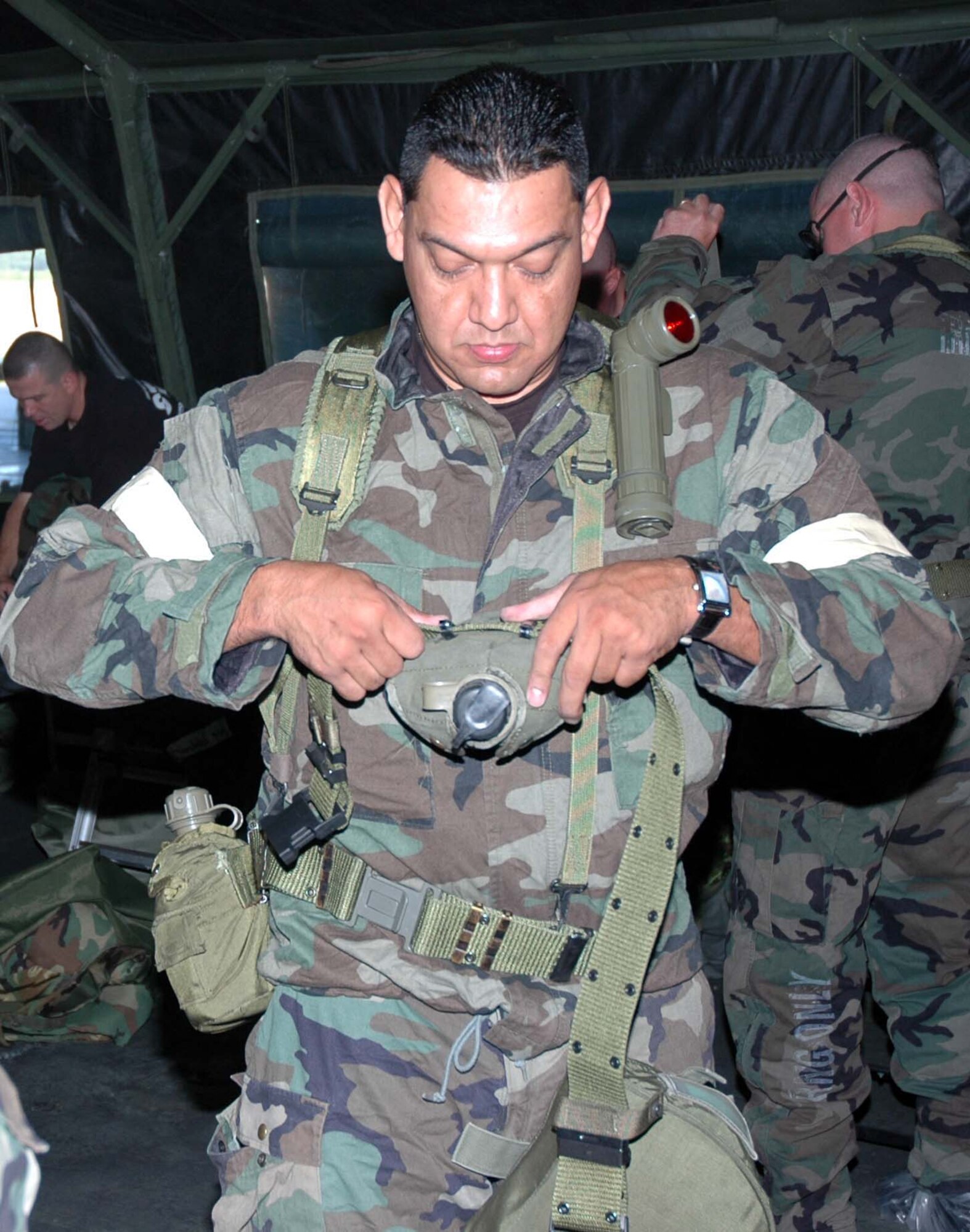 MCGUIRE AIR FORCE BASE,N.J. -- Tech. Sgt. Javier Diaz preps his web belt and canteen during a recent Battle Axe training session. Battle Axe is a half-day course designed to reinforce ability to survive and operate skills in a war environment.  Preparation for the upcoming Operational Readiness Inspection includes sending ORI participants through the Battle Axe training facility.  (U.S. Air Force photo/Master Sgt. Charles W. Kramer) 