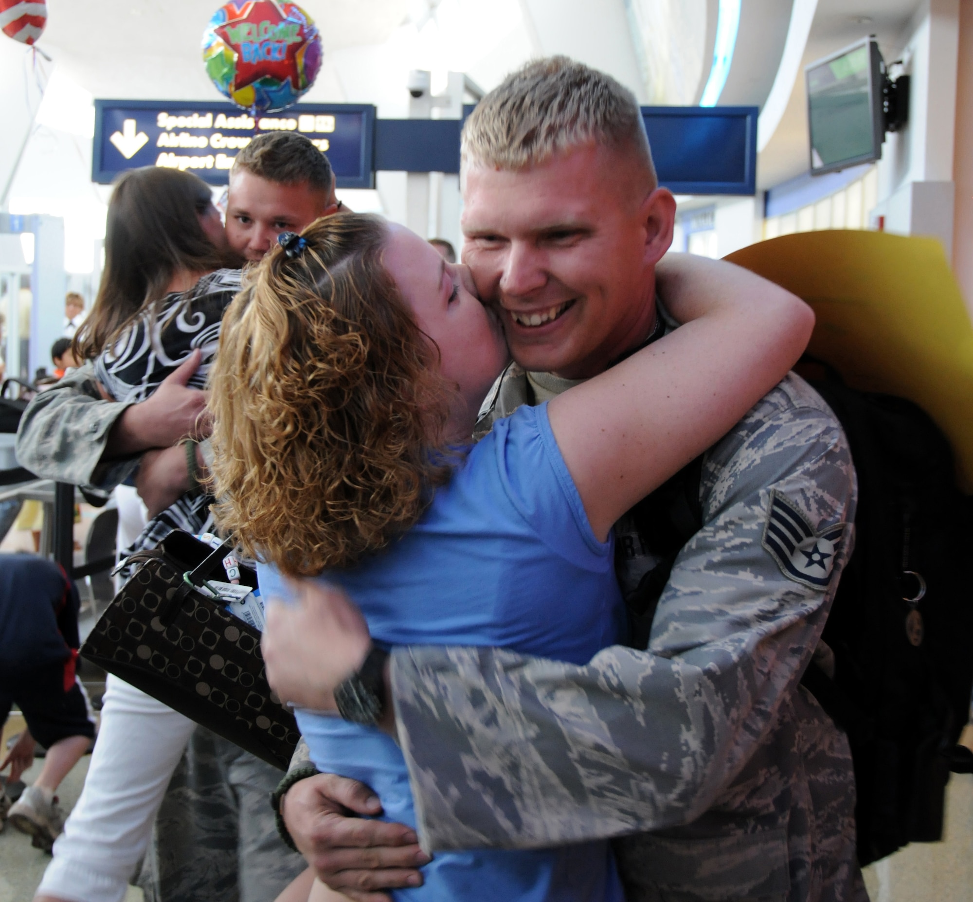 Staff Sgt. Ernest Covell receives a warm embrace from his wife. Senior Airman Derek Cutter is in the background with his girlfriend. 