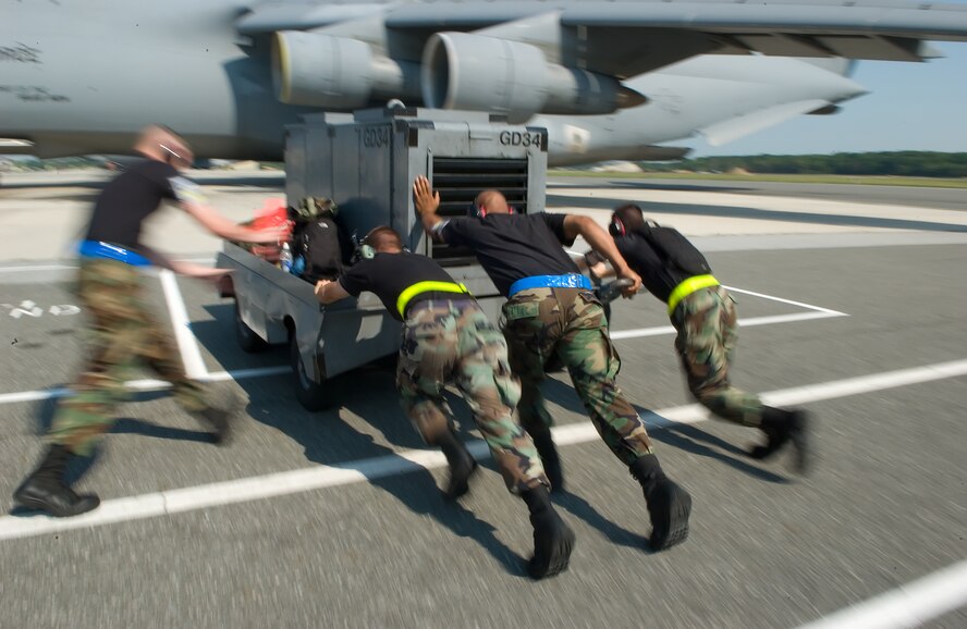 512th and 436th Airlift Wing Airmen push a generator into place next to a C-5 Galaxy here Aug. 1 as Team Dover warriors arrive after completing the employment portion of the Operational Readiness Exercise at the Combat Readiness Training Center in Alpena, Mich. Team Dover earned an Excellent for their efforts during the inspection. (U.S. Air Force photo/Jason Minto)