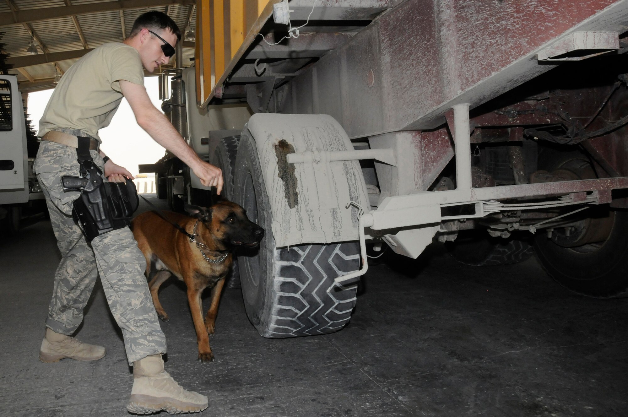 Staff Sgt. Logan Ray, military working dog handler assigned to the 379th Expeditionary Security Forces Squadron, check vehicles with his military dog, Lenox, Aug. 19, 2008, at an undisclosed air base in Southwest Asia. Sergeant Ray and the rest of his team ensure the safety and security of the air base by carefully inspecting all incoming vehicles for explosives and weapons. Sergeant Ray, a native of Hyattsville, Md., is deployed from Andrews Air Force Base, Md., in support of Operations Iraqi Freedom, Enduring Freedom and Joint Task Force-Horn of Africa. (U.S. Air Force photo by Staff Sgt. Darnell T. Cannady/Released)
