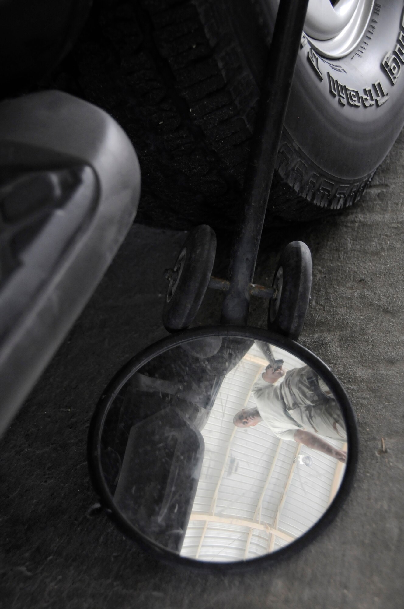 Senior Airman Ron Turner, search member assigned to the 379th Expeditionary Security Forces Squadron, inspects the under carriage of a vehicle using a search mirror Aug. 19, 2008, at an undisclosed air base in Southwest Asia. Airman Turner and the rest of his team ensure the safety and security of the air base by carefully inspecting all incoming vehicles for explosives and weapons. Airman Turner, a native of Jacksonville, Fla., is deployed from Randolph Air Force Base, Texas, in support of Operations Iraqi Freedom, Enduring Freedom and Joint Task Force-Horn of Africa. (U.S. Air Force photo by Staff Sgt. Darnell T. Cannady/Released)