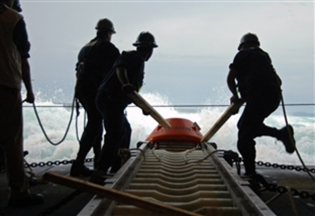 U.S. sailors aboard USS Tarawa slide an inert training mine into the Pacific Ocean, Aug. 10, 2008, during Fuerzas Aliadas Panamax 2008. Panamax is a U.S. Southern Command joint and multinational annual exercise involving 20 countries. 