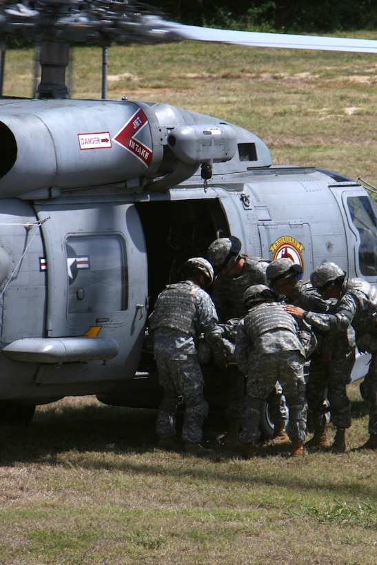 Soldiers with the 545th Transportation Battalion stationed out of Hickam Air Force Base load an injured soldier inside a SH-20B Seahawk at Landing Zone Boondocker during medical evacuation training Aug. 19. The soldiers worked with Helicopter Anti-Submarine Squadron Light 37 to perform the medivacs.