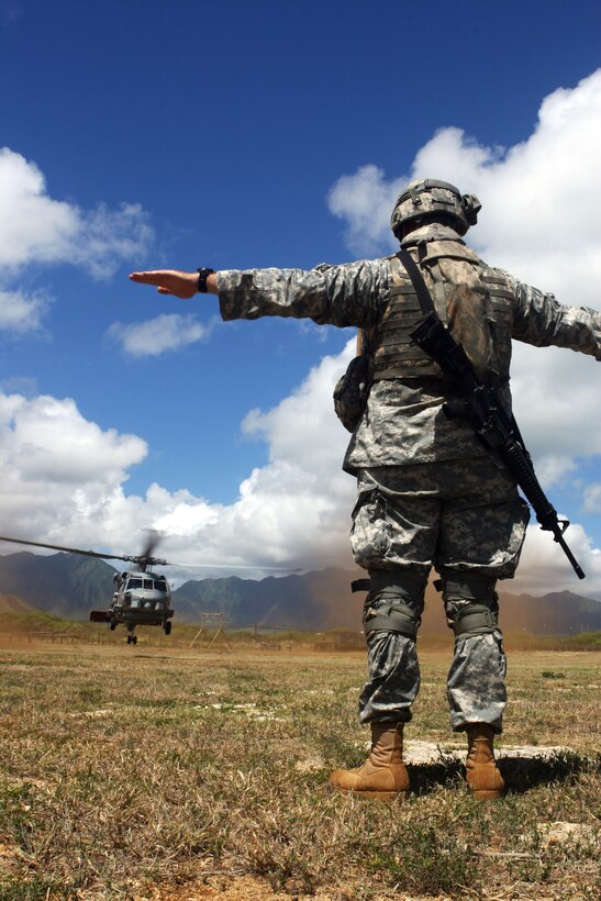 Spc. Charles Jost, medic, Logistics Support Vessel 5, 545th Transportation Battalion, guides a from Helicopter Anti-Submarine Squadron Light 37 down during medical evacuation training at Landing Zone Boondocker Aug. 19. The training marked the first time the squadron recently conducted exercises with the Army.