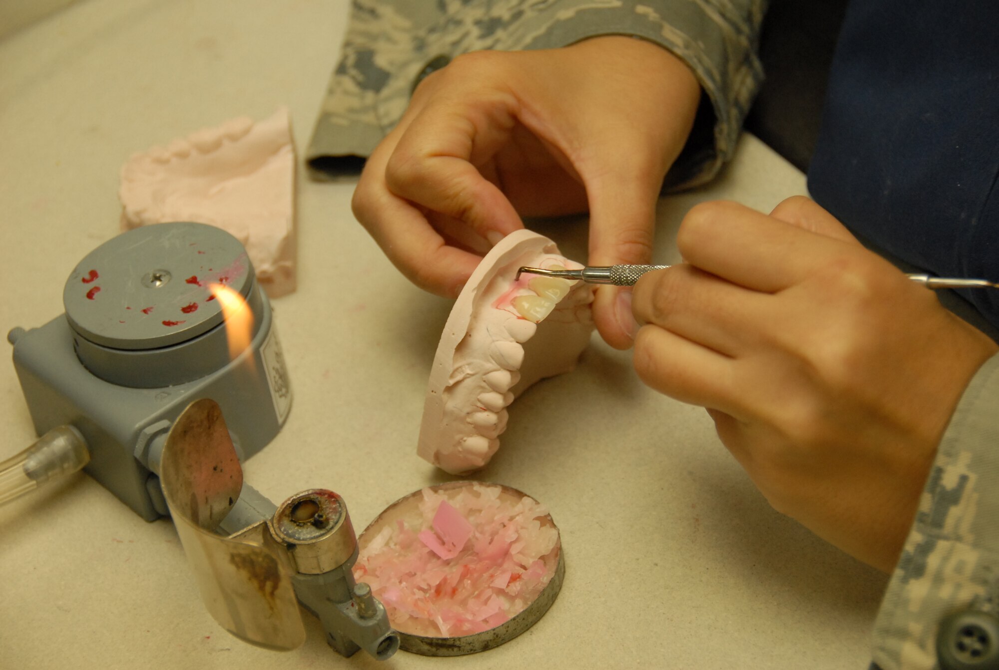 Staff Sgt. Andi Stevenson, a dental lab technician for the 18th Wing Dental
Squadron Area Dental Lab, applies paint to a metal substructure to make
a crown porcelain. The area dental lab services to 52 different U.S. Pacific
Command installations in Korea, Japan, Guam, Alaska and Navy ships at
sea.  (U.S. Air Force photo/Airman 1st Class Aaron Johnson)