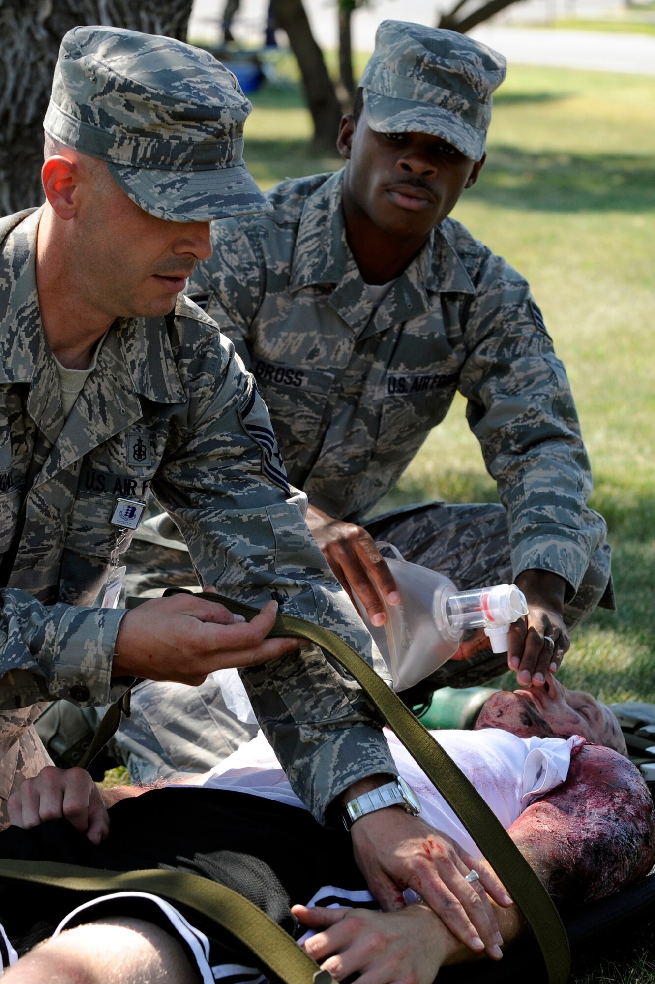 (left) Master Sgt. Casey McDougall, 28th Medical Group NCO in charge of aerospace medicine, and Senior Airman Tim Gross, 28th MDG health services management journeyman, stabilize Staff Sgt. Grant Gammons, 28th Logistics Readiness Squadron air transportation technician during 28 MDG functional exercise here Aug. 21. The exercise was designed to test the initial response procedures of medical personnel to contaminated casualties. (U.S. Air Force photo/Airman Matthew Flynn)

