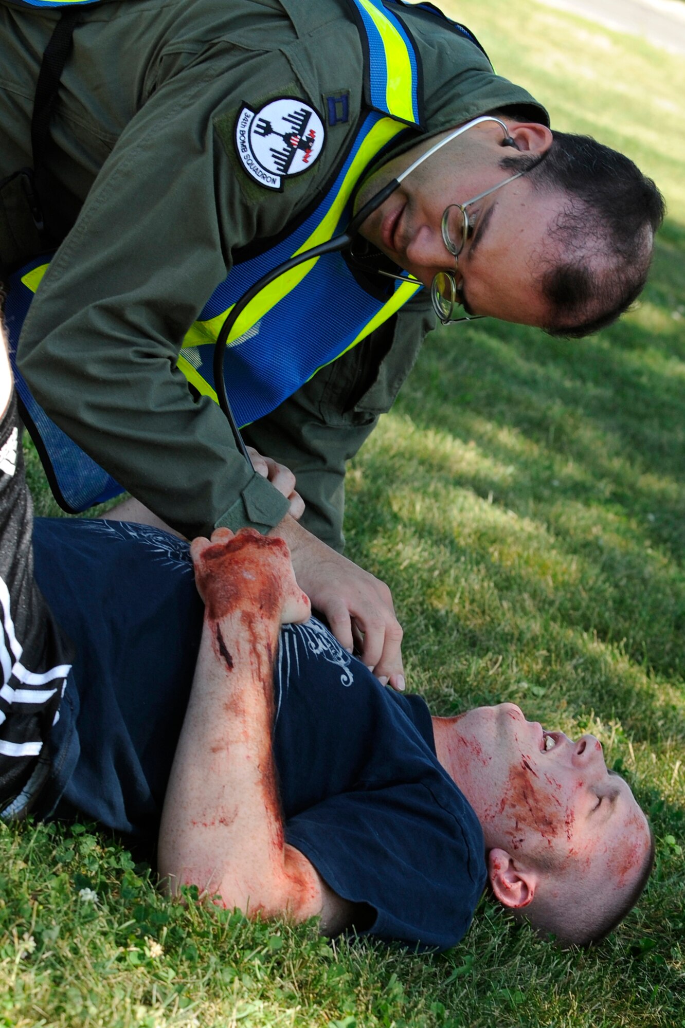 Capt. Joseph Huseman, 34th Bomb Squadron flight surgeon, checks the vitals of Senior Airmen Morgan Whitley, 28th Logistics Readiness Squadron air transportation technician, during a 28th Medical Group functional exercise here Aug. 21.  The exercise was a simulated chemical explosion of hydrogen fluoride. (U.S. Air Force photo/Airman Matthew Flynn)


