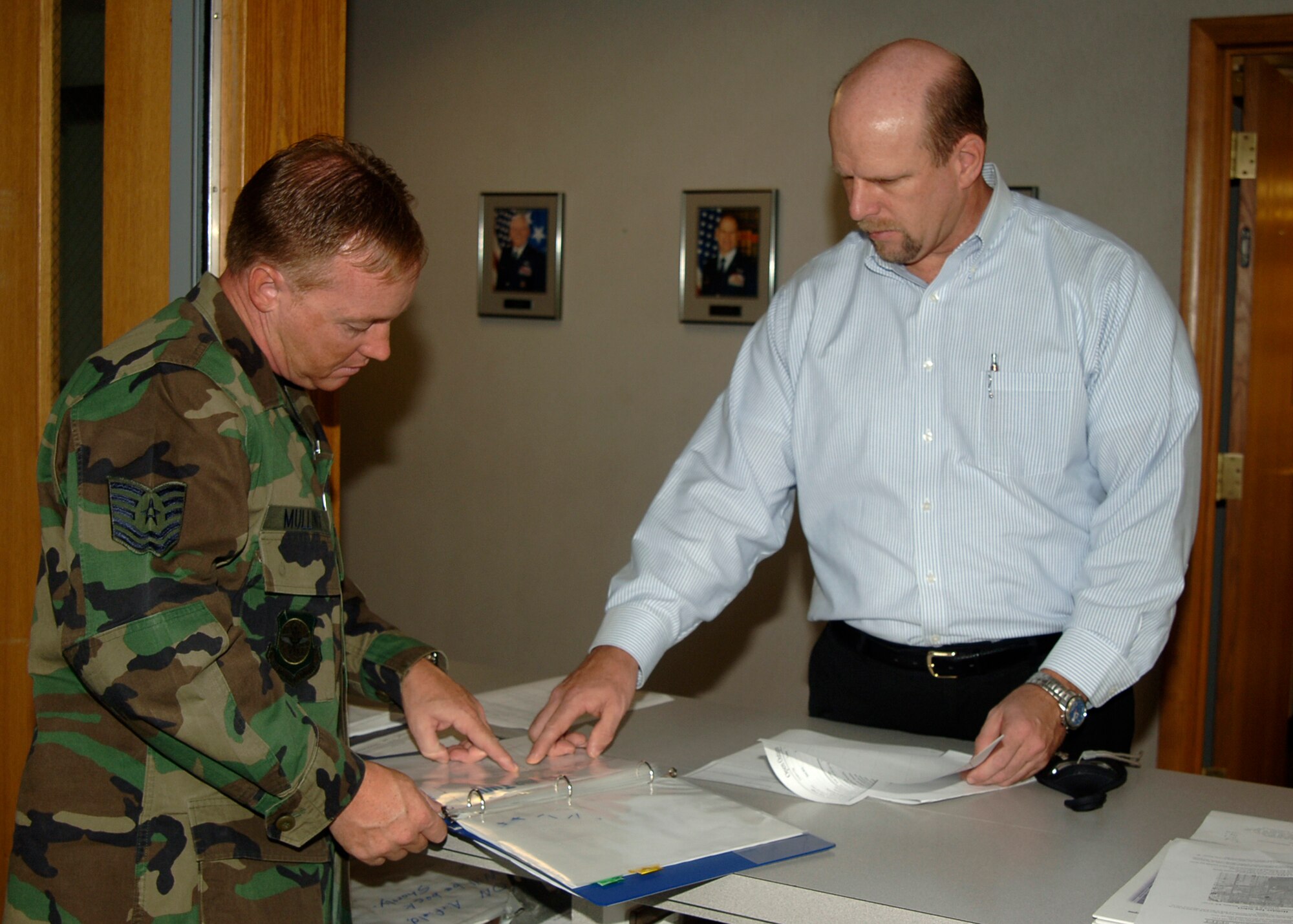 MCCONNELL AIR FORCE BASE, Kan. -- Tech. Sgt. Randall Mullinix, 22nd Operations Support Squadron, reviews an airfield lighting outage form with James Knight, an Air Traffic System Evaluation Program inspector during an ATSEP inspection at base operations, Aug 19. Personnel from the base safety office, the 22nd Civil Engineer Squadron, and the 22nd Communications Squadron were also inspected along side the airfield managers and air traffic controllers. (Photo by Airman Justin Shelton)