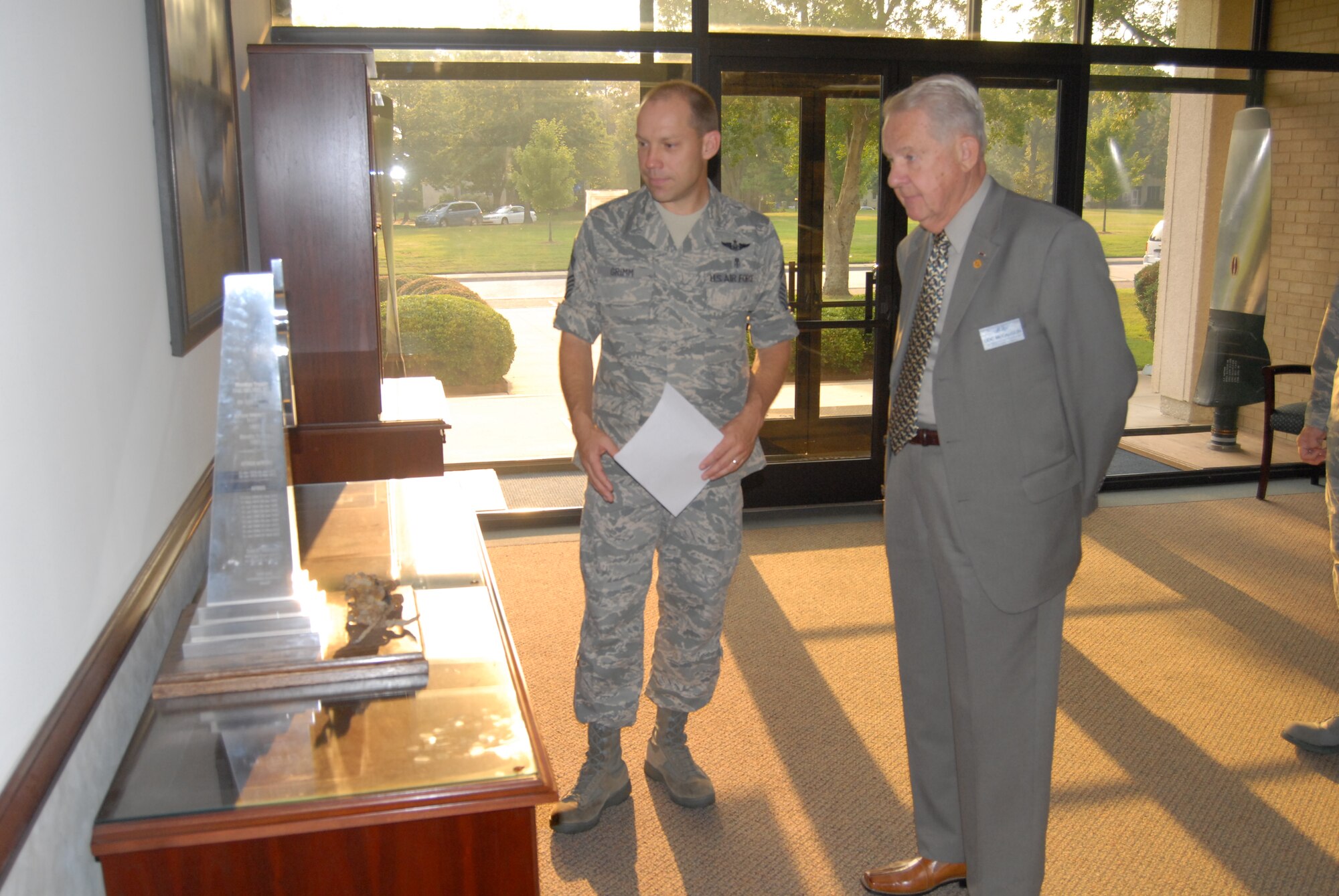 Chief Master Sgt. Michael Grimm, 43rd Airlift Wing Command Chief, talks about Pope's Heraldic Device with Chief Master Sgt. (Ret.) John McCauslin, International President of the Air Force Sergeants Association. Chief McCauslin visited Pope Aug. 9 and toured all of Team Pope's units, including the Air Combat Command, Air Education and Training Command and Air Force Special Operations Command tenants. (U.S. Air Force Photo by 2nd Lt. Chris Hoyler)