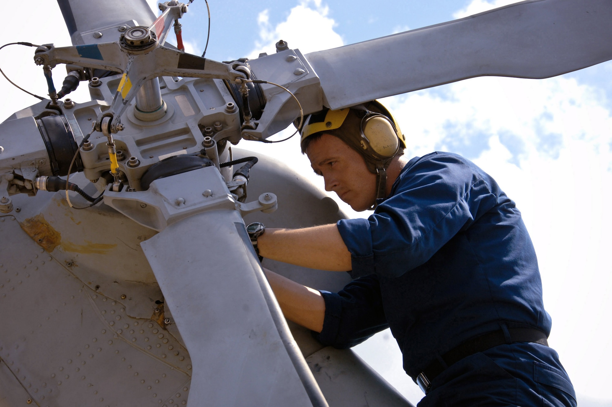 Navy Seaman Sean Sadler works on the rear rotor of a Navy SH-60B Seahawk Aug. 20 at Maxwell Air Force Base, Ala. Based at Naval Station Mayport in Jacksonville, Fla., HSL-42 aircraft and personnel flew to Maxwell AFB for shelter from Tropical Storm Fay. Seaman Sadler is a helicopter mechanic from Helicopter Anti-Submarine Squadron Light 42. (U.S. Air Force photo/Donna Burnett) 
