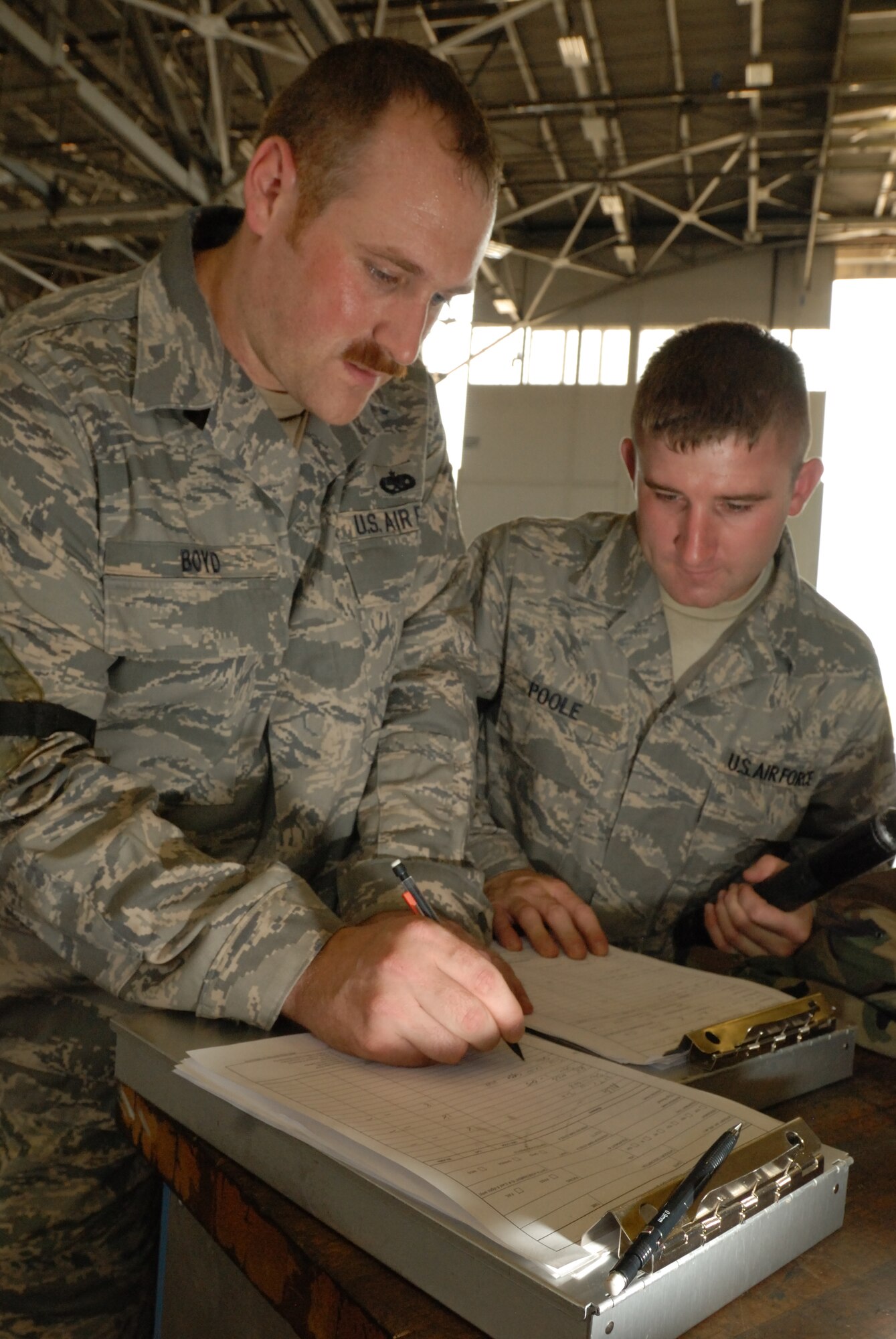 LITTLE ROCK AIR FORCE BASE, Ark.-- Tech. Sgt. Jeremy Boyd and Staff Sgt. Chris Poole, 314th Maintenance Group quality assurance inspectors, finish the documentation for C-130 records on the flightline. They work with a team of 18 to complete approximately 400 inspections a month. (U.S. Air Force photo by Senior Airman Christine Clark) (Released)