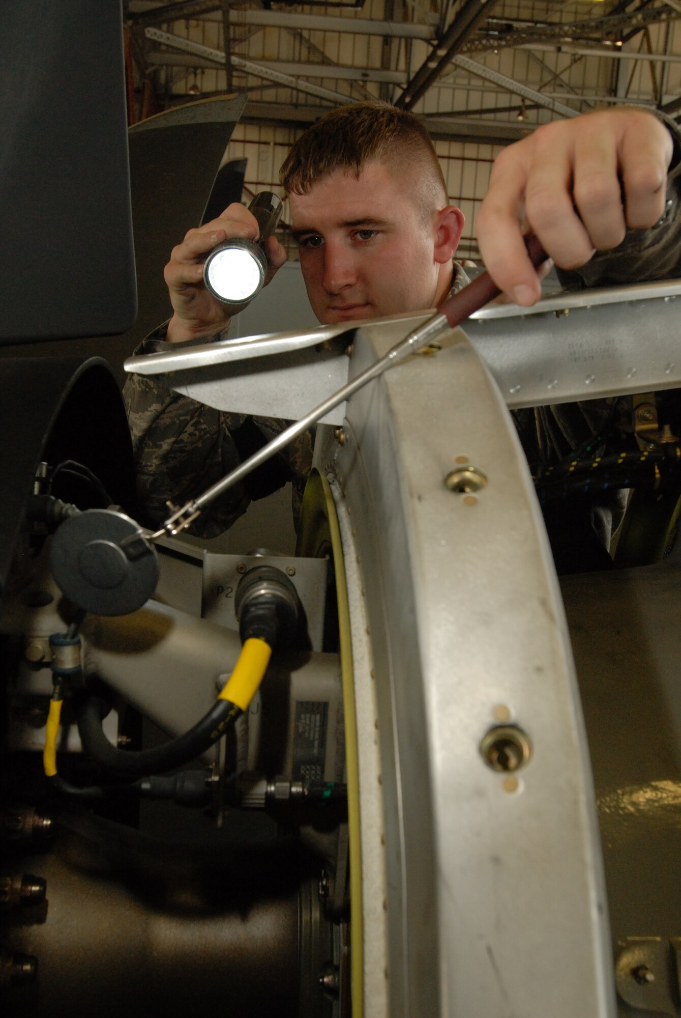 LITTLE ROCK AIR FORCE BASE, Ark.--Staff Sgt. Chris Poole, 314th Maintenance Group, looks at the C-130 engine closely on the flightline July 29.  Sergeant Poole is newly assigned to QA as an engines specialist inspector. (U.S. Air Force photo by Senior Airman Christine Clark) (Released)