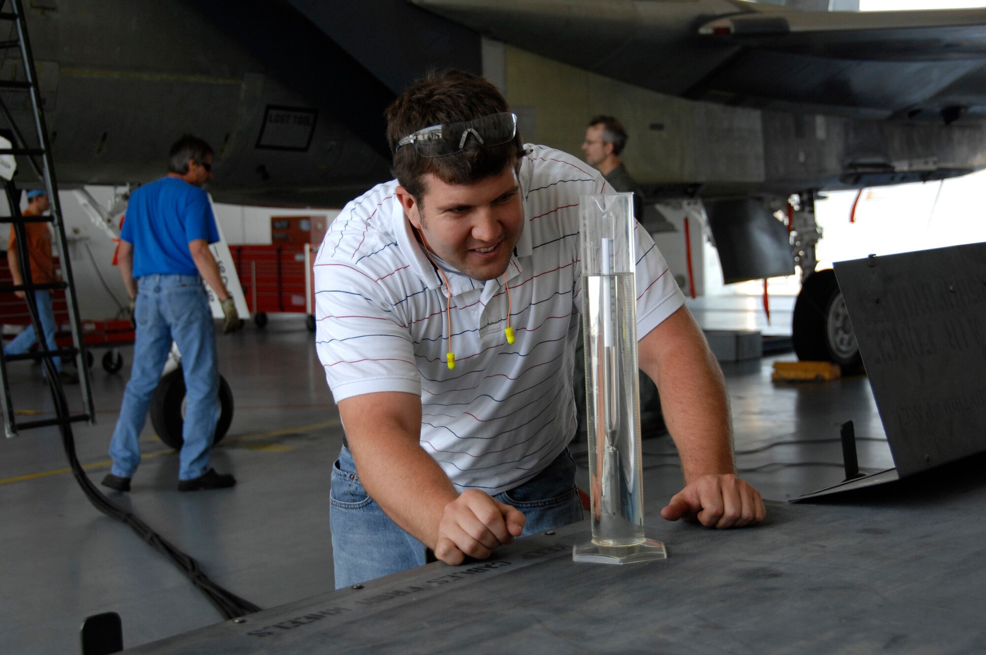 Ryan Mead checks the density of the SJ-8 50/50 blended synthetic fuel before use in two successful F-15 flight tests Aug. 19. Mr. Mead is an F-15 fuels engineer at Warner Robins Air Logistics Center, Robins Air Force Base, Ga. (Air Force photo by Claude Lazzara)