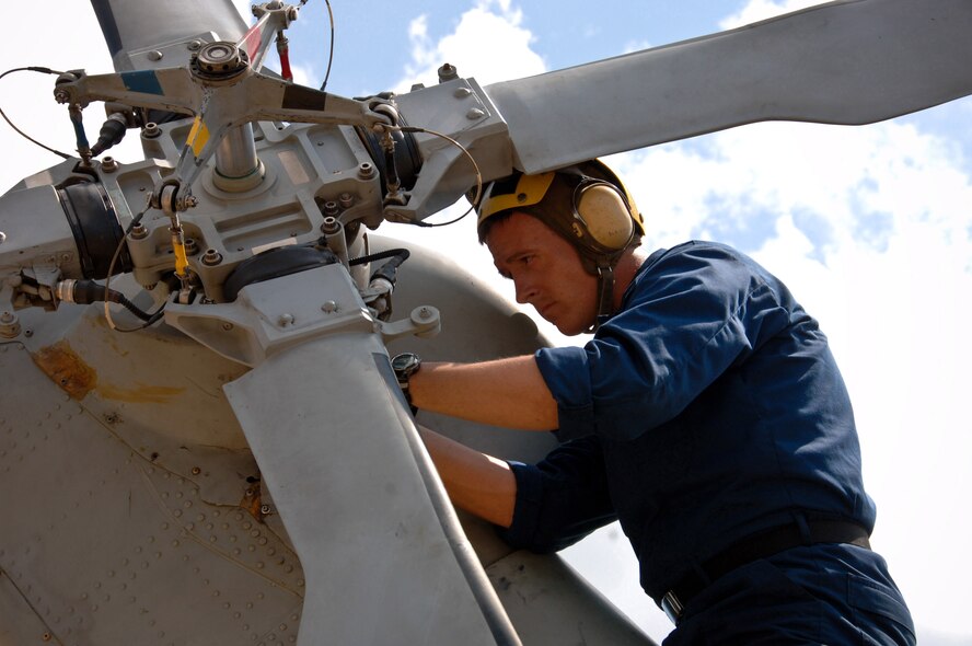 Seaman Sean Sadler, a helicopter mechanic from Helicopter Anti-Submarine Squadron Light 42, works on the rear rotor of a Navy SH-60B Seahawk on the Maxwell flightline Aug. 20. Based at Naval Station Mayport in Jacksonville, Fla., HSL-42 aircraft and personnel flew to Maxwell for shelter from Tropical Storm Fay. (U.S. Air Force photo/Donna Burnett) 