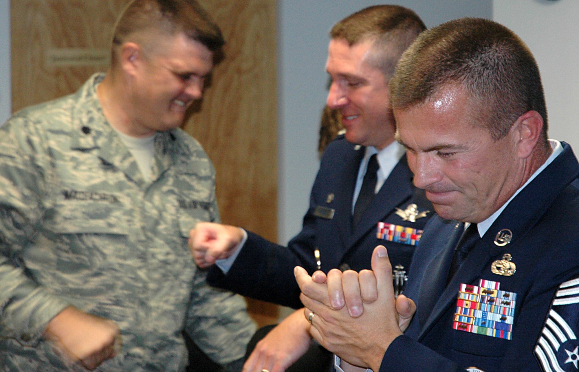 Chief Master Sgt. Roger Sirois, 319th Recruiting Squadron superintendent, applauds his unit’s outstanding rating Aug. 15 as Lt. Col. Jeffrey Maceachron, 360th Recruiting Group deputy commander, congratulates Lt. Col. Jeffrey Keckley, 319th RCS commander. The Air Education Training Command Inspector General inspection out brief took place at squadron headquarters in Portsmouth, N.H. The rating is the first of such Air Force recruiting squadron achievements in four years. (U.S. Air Force photo/Senior Master Sgt Robert Barrett)