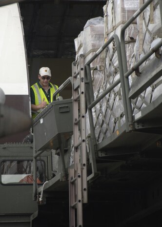 A United Parcel Service worker guides a 60K-loader holding more than 50 tons of meals ready to eat to the UPS 747 cargo door on the Charleston AFB flightline Aug. 19. Approximately 400 tons of food and tents will be airlifted from Charleston AFB to Republic of Georgia refugees as part of the United States humanitarian aid. (U.S Air Force photo/Airman 1st Class Timothy Taylor)