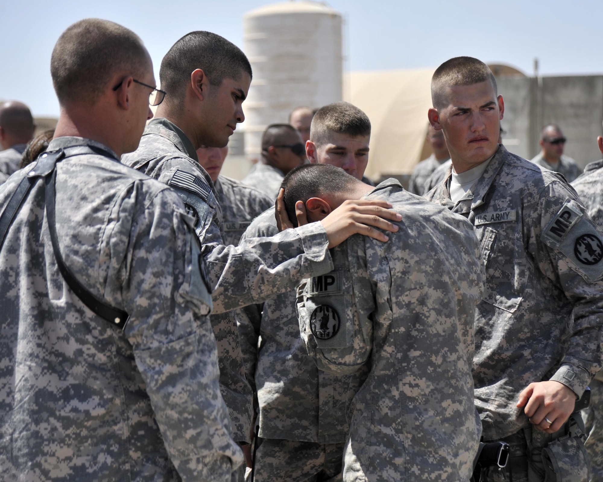 8/14/2008 - SATHER AIR BASE, Iraq ? Private 1st  Class Nicholas Fleming (right) takes a last look back at the aircraft that carried the body of fellow Soldier and friend Cpl. James Hale home from Iraq,  as Capt. Daniel Gonzales consoles Cpl. Leo Arce. Soldiers from the 978th Military Police Company and Airmen from the 447th Air Expeditionary Group gathered to provide patriot honors to Corporal Hale, who was killed July 13 in Baghdad by a roadside bomb.  The patriot ceremony marks the beginning of the journey home for U.S. service members killed while serving in deployed locations. (U.S. Air Force Photo by Master Sgt. Brian Davidson)