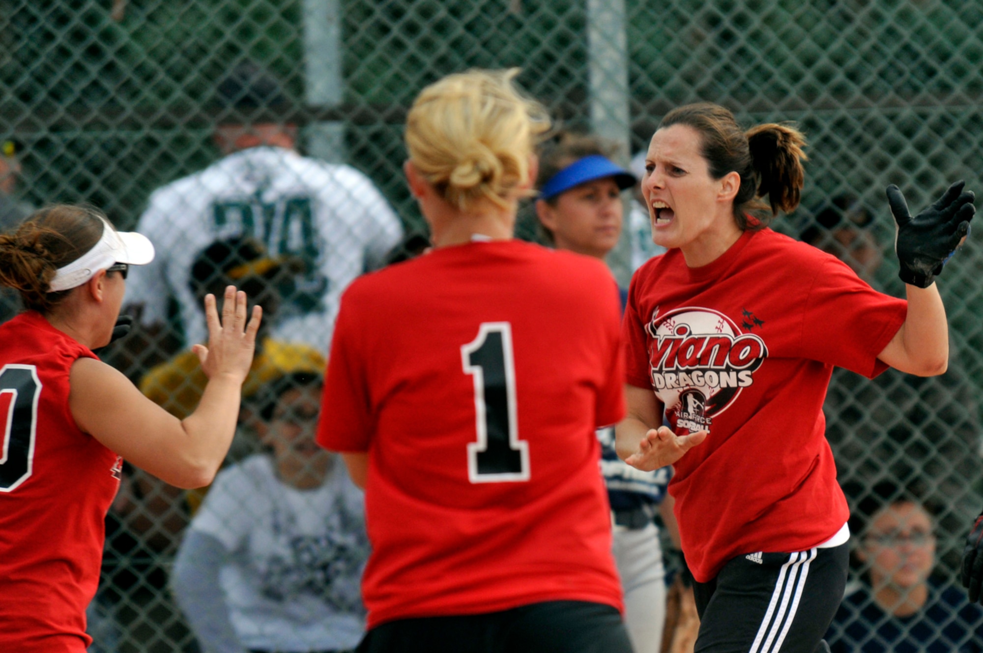 Mary Wilkerson, 1st basemen and pitcher for the Aviano Lady Dragons celebrates with fellow teammates after scoring the team's first run of the game Aug. 16 at RAF Lakenheath, England. The Lady Dragons fell to the Lakenheath Lady Eagles 10 - 3. (U.S. Air Force photo by Airman Perry Aston)