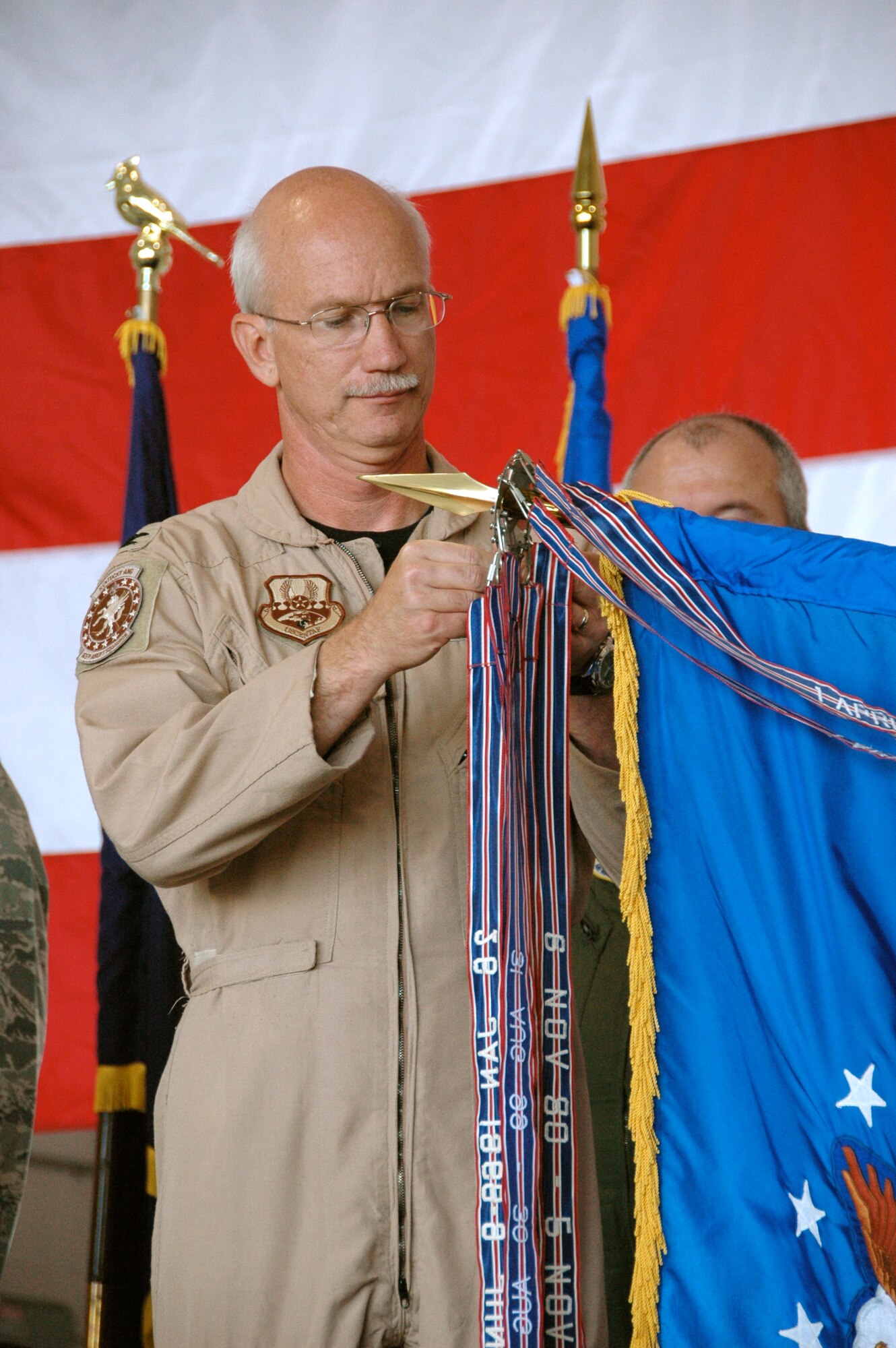 Col. Mark Kraus, commander of the Kentucky Air Guard’s 123rd Airlift Wing, attaches a 12th Air Force Outstanding Unit Award streamer to the wing’s colors during a Sept. 16 awards ceremony held in the base Fuel Cell Hangar.

The honor recognizes the wing’s achievements from March 6, 2003 to March 15, 2004, when unit personnel deployed around the world for combat and combat support operations in the Global War on Terror, Operation Iraqi Freedom and Operation Enduring Freedom. (Capt. Dale Greer/KyANG)