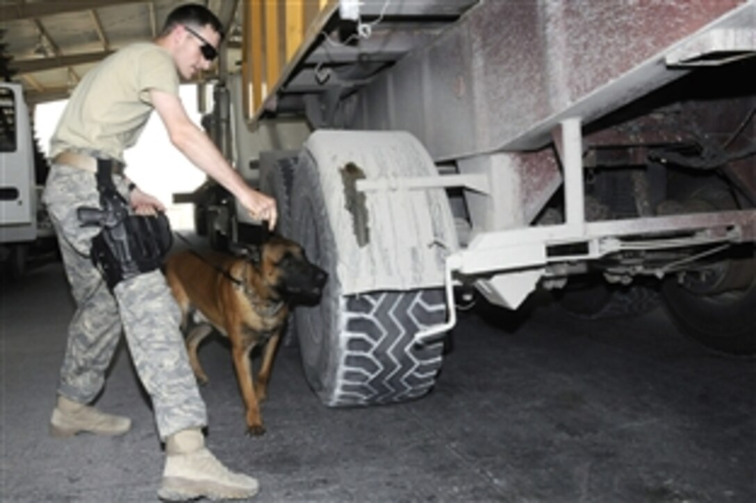 U.S. Air Force Staff Sgt. Logan Ray and Lennox, his working dog, check a truck waiting to enter an air base in Southwest Asia, Aug. 19, 2008. Ray, a military working dog handler is assigned to the 379th Expeditionary Security Forces Squadron, and the rest of his team ensure the safety and security of the air base by carefully inspecting all incoming vehicles for explosives and weapons. 