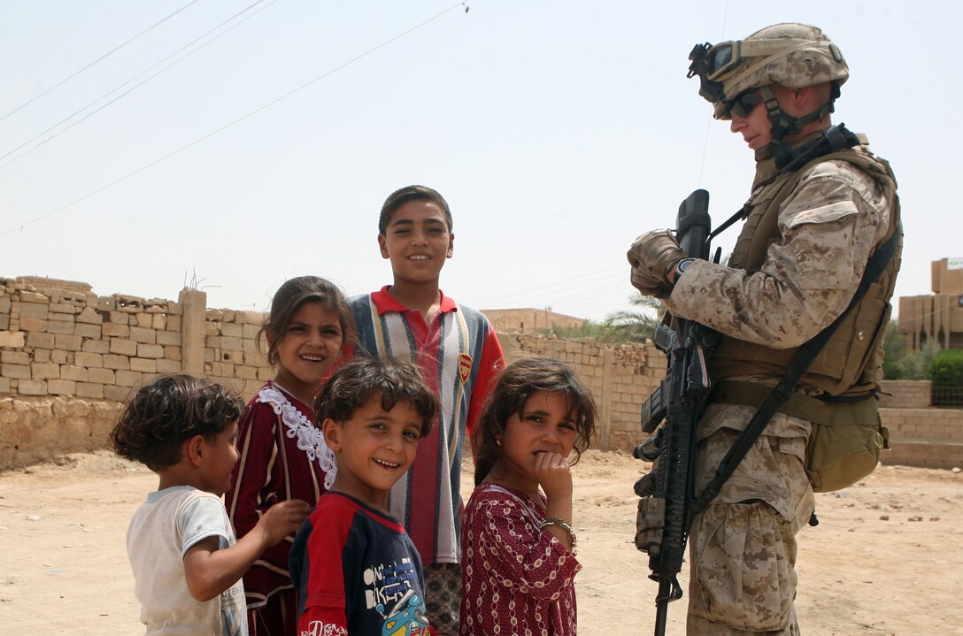 Petty Officer 3rd Class Andrew Harang, senior corpsman with Company C, Task Force 1st Battalion, 2nd Marine Regiment, Regimental Combat Team 5, bonds with children in Habbaniyah, Iraq, a major city in the battalion's former area of operations. The battalion recently completed the movement from RCT-1's area of operations and plans to continue its mission to facilitate a sustainable Iraqi infrastructure in Rawah, Iraq.