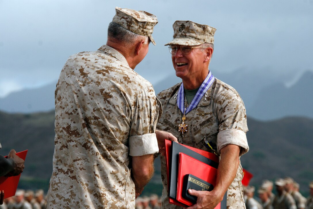 Lt. Gen. John F. Goodman, (right) commander, U.S. Marine Corps Forces, Pacific, shakes hands with Gen. James T. Conway, (left) Commandant of the Marine Corps, after receiving awards during his change of command and retirement ceremony on the flightline here Aug. 22.
