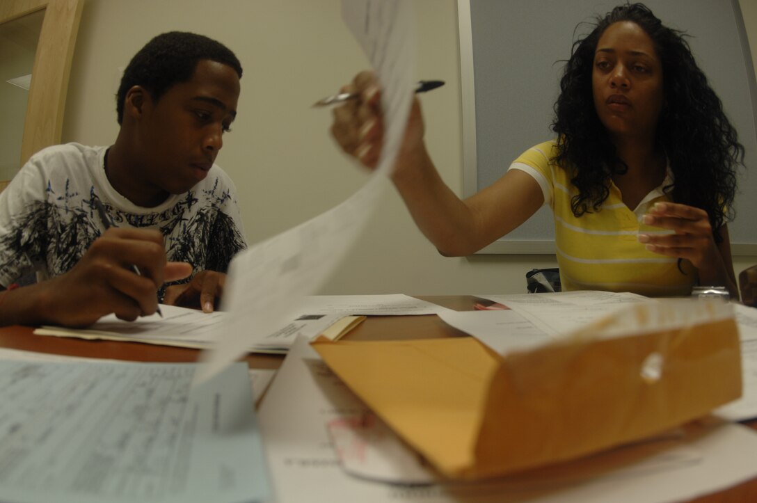 Mrs. Cherre Johnson, right, helps her son, Raheem, 15, prepare registration papers for admission at Dr. Henry A. Wise Jr. High School, Upper Marlboro, Md. Andrews has a supportive relationship with local school districts Partners-In-Education program, which focuses on taking volunteer partnership responsibilities for several schools. The schools serving Andrews children are Francis T. Evans Elementary, Clinton, Md., Stephen Decatur Middle School, Clinton, Md. and Dr. Henry A. Wise Jr. High School, Upper Marlboro, Md. (U.S. Air Force photo by Janiqua Robinson)