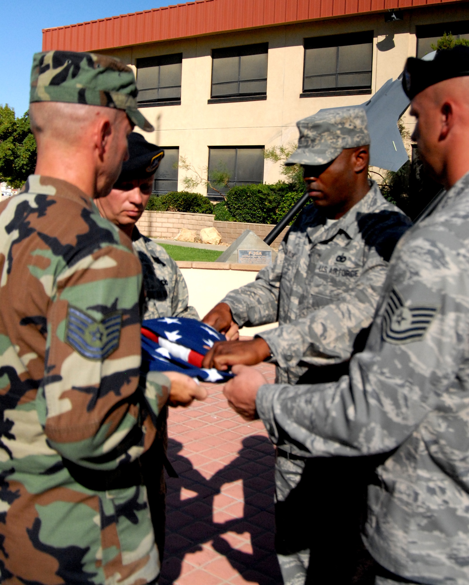 Edwards Airmen fold the flag during a retreat ceremony in front of the Air Force Flight Test Center here Aug. 21. This culminated a 3-day senior noncommissioned officers course designed to provide a foundational basis to enhance effectiveness as leader. (Air Force photo by Airman 1st Class William O'Brien)